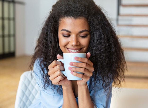 一杯のコーヒーを持っている若い女性