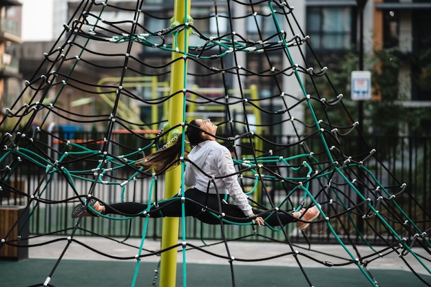 Young woman having fun on the rope pyramid