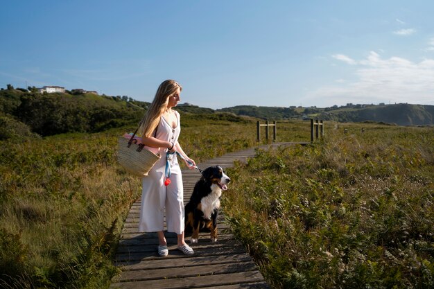 ビーチで犬を楽しんでいる若い女性