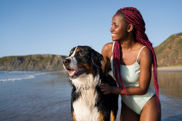 Young woman having fun with  dog at the beach