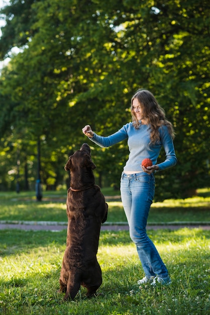 Foto gratuita giovane donna che si diverte con il suo cane in giardino