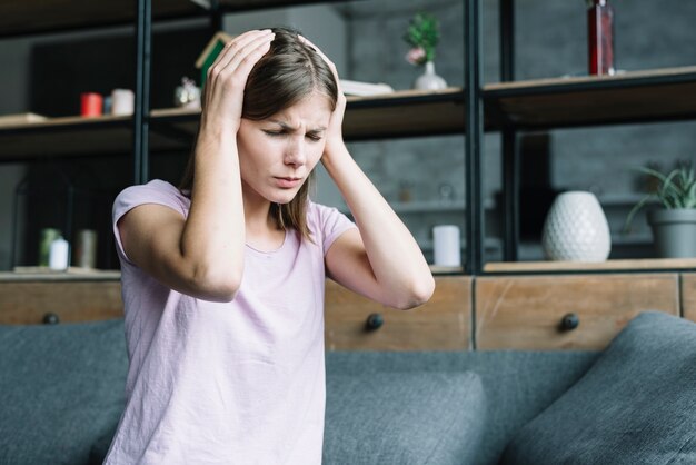 Young woman having headache at home