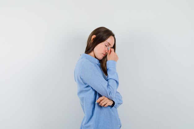 Young woman having a headache on white background