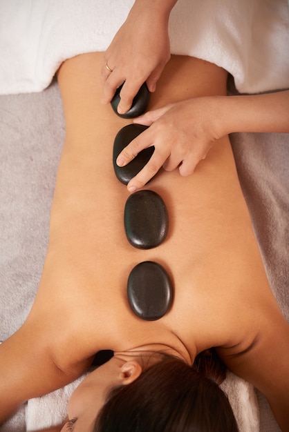 Young Woman Having Hot Stone Therapy Massage In Spa Salon