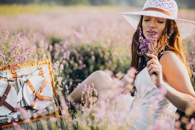 Young woman having picnic in a lavander field