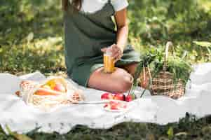 Foto gratuita giovane donna che ha un picnic con spuntini sani