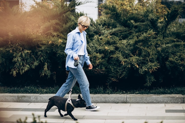 Young woman having a walk with her pet french bulldog