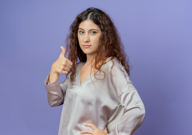 young woman her thumb up isolated on blue