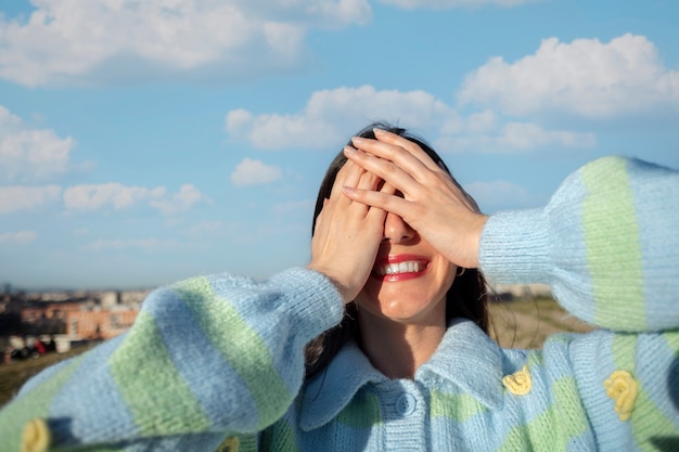 無料写真 屋外のフィールドで彼女の顔を隠す若い女性