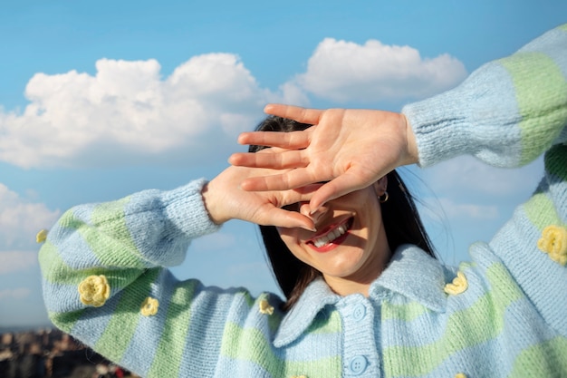 無料写真 屋外のフィールドで彼女の顔を隠す若い女性