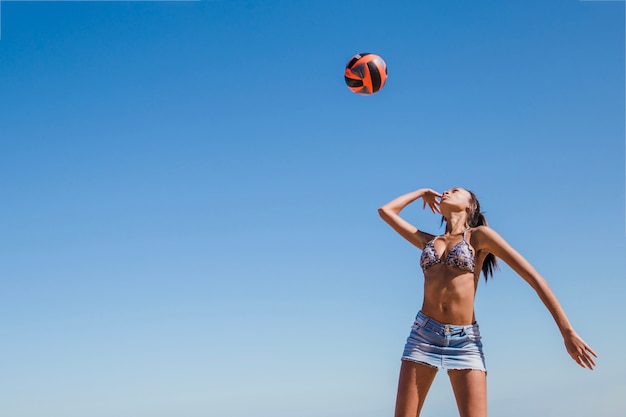 Free photo young woman hitting volleyball