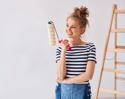 young woman holding a paint roller