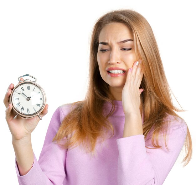 Young woman holding alarm clock