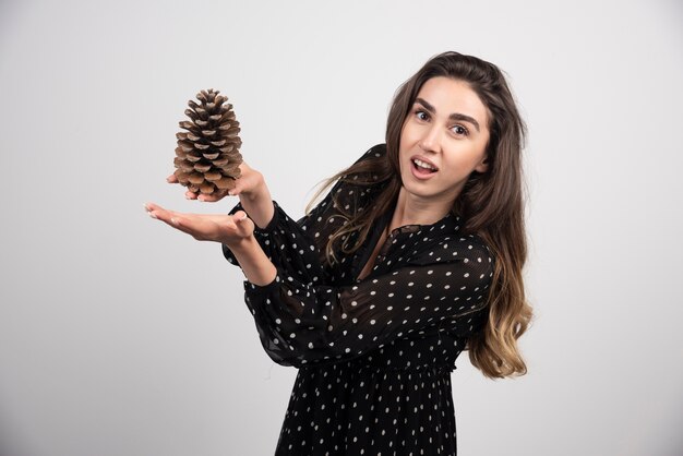 Young woman holding a big pinecone 