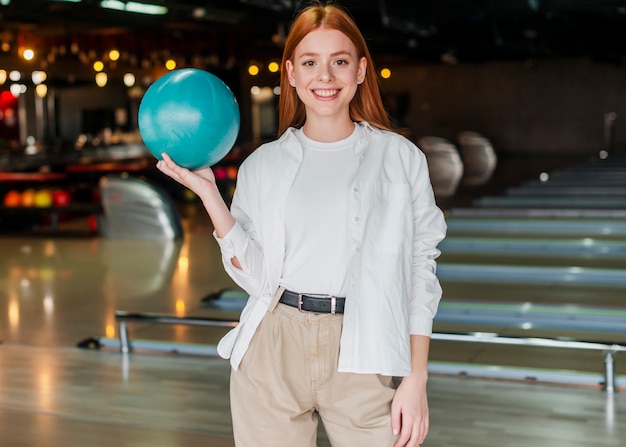 Foto gratuita giovane donna che tiene la palla da bowling