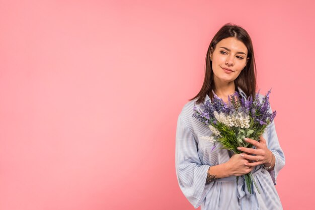Young woman holding bunch of flowers