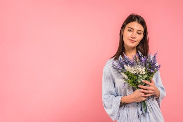 Young woman holding bunch of flowers