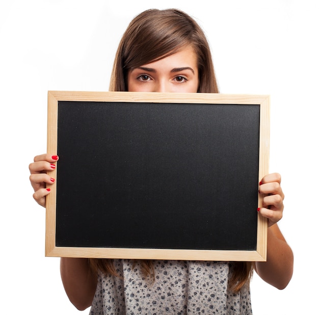 Young woman holding a chalkboard under her eyes