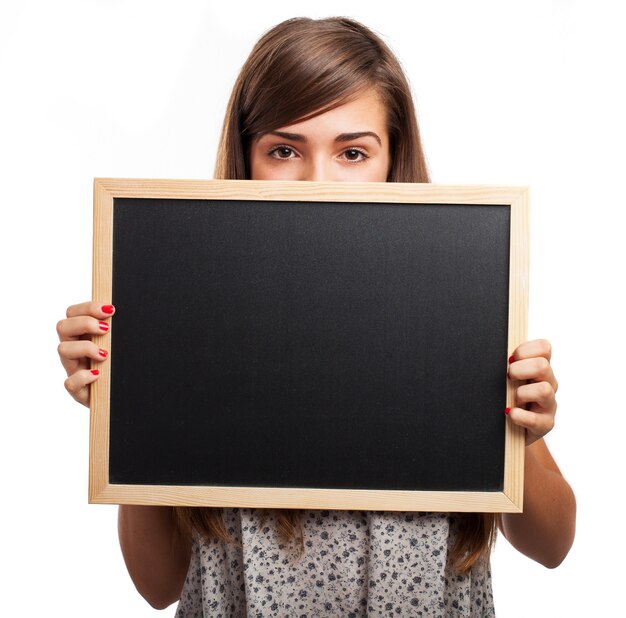 Young woman holding a chalkboard under her eyes