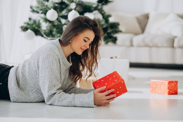 クリスマスプレゼントを保持している若い女性