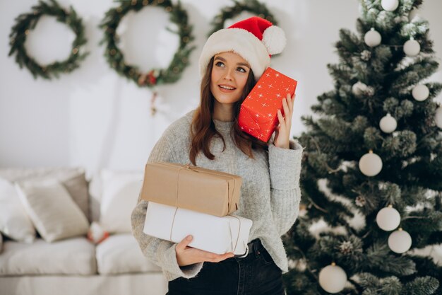 クリスマスプレゼントを保持している若い女性