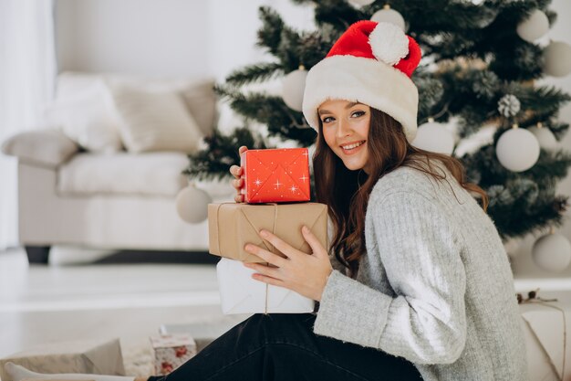 クリスマスプレゼントを保持している若い女性