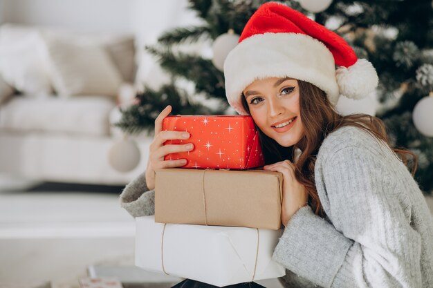 クリスマスプレゼントを保持している若い女性