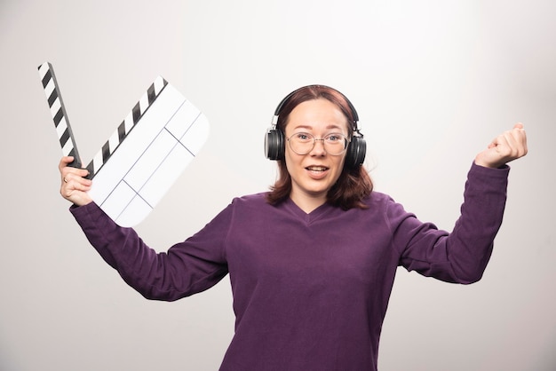 Free photo young woman holding a cinema tape on a white . high quality photo