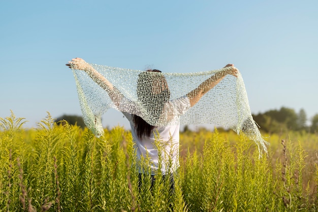 Free photo young woman holding an cloth in the air