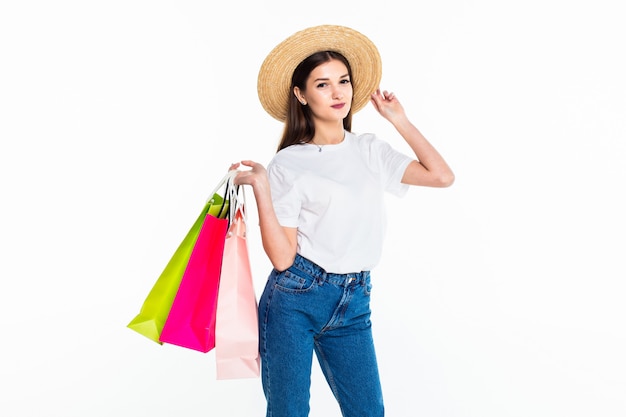 Young woman holding colorful bags isolated on white wall