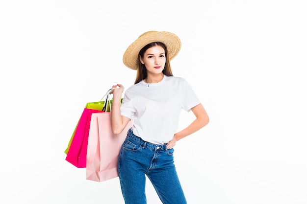 Young woman holding colorful bags isolated on white wall