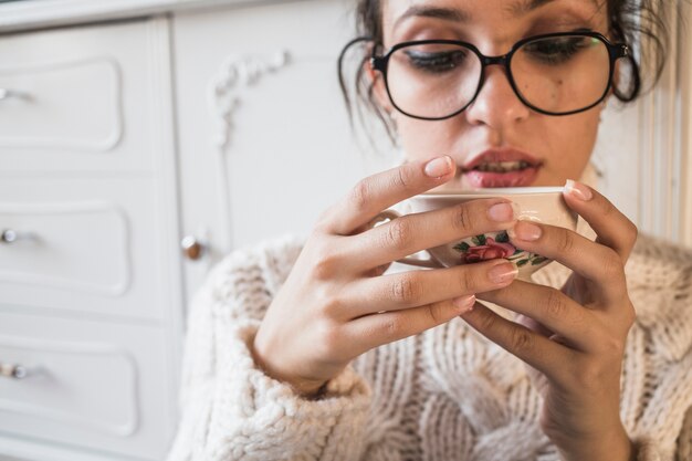 Giovane donna che tiene tazza di caffè