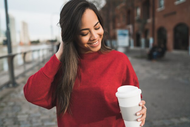 한 잔의 커피를 들고하는 젊은 여자.