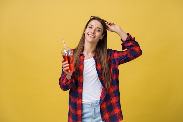 Young woman holding and drinking cold drink beverage in casual clothes. pretty girl smiling happy laughing looking at camera.