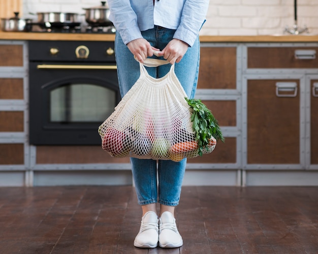 Young woman holding eco bag with organic groceries