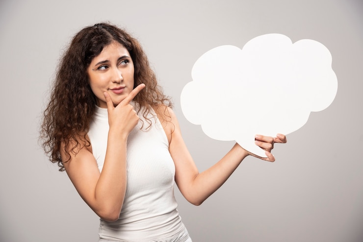Free Photo young woman holding empty blank white speech bubble. high quality photo