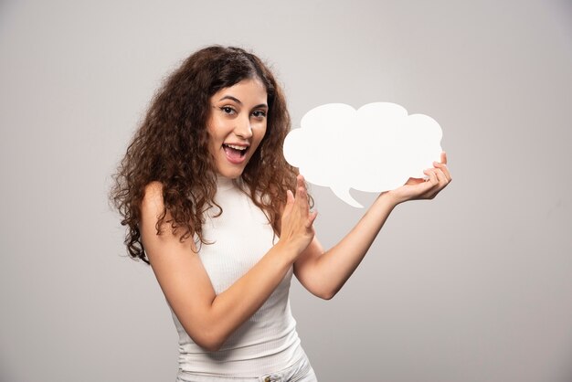 Young woman holding empty blank white speech poster. High quality photo