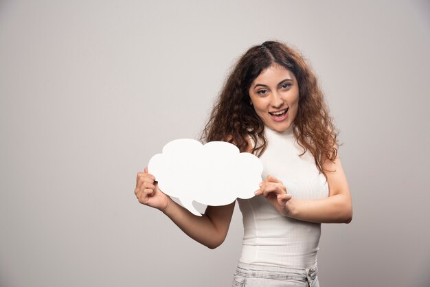 Young woman holding empty blank white speech poster. High quality photo