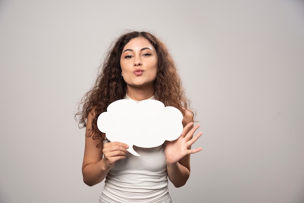 Young woman holding empty blank white speech poster. High quality photo