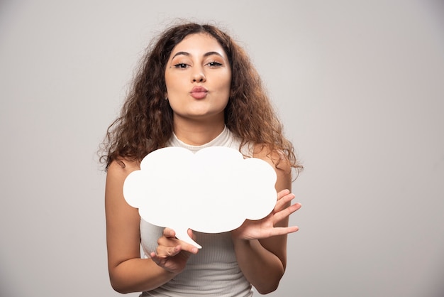 Young woman holding empty blank white speech poster. High quality photo