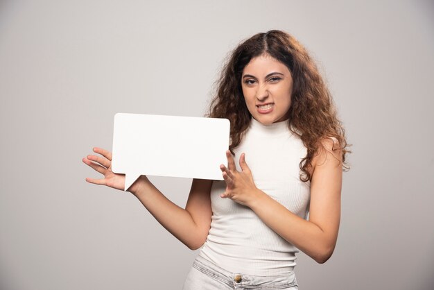 Young woman holding empty blank white speech poster. High quality photo