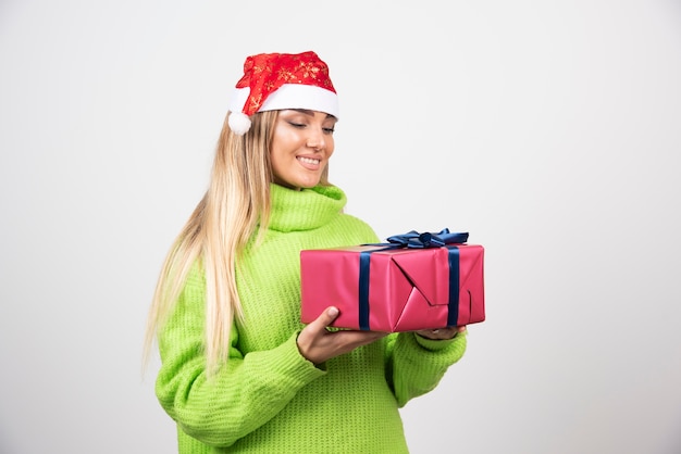 Молодая женщина, держащая праздничный рождественский подарок.