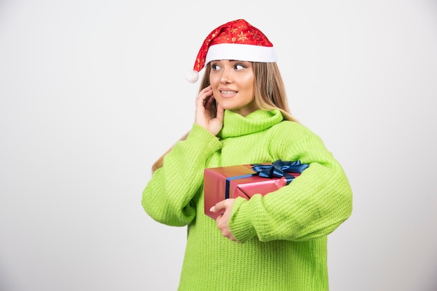 お祝いのクリスマスプレゼントを保持している若い女性