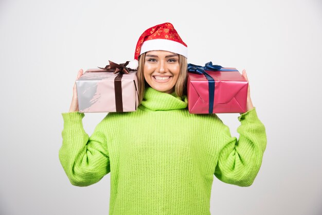 Young woman holding festive Christmas presents .