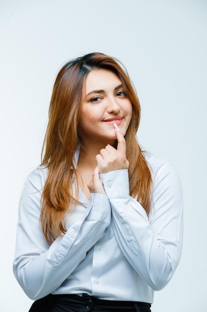 Young woman holding finger on mouth