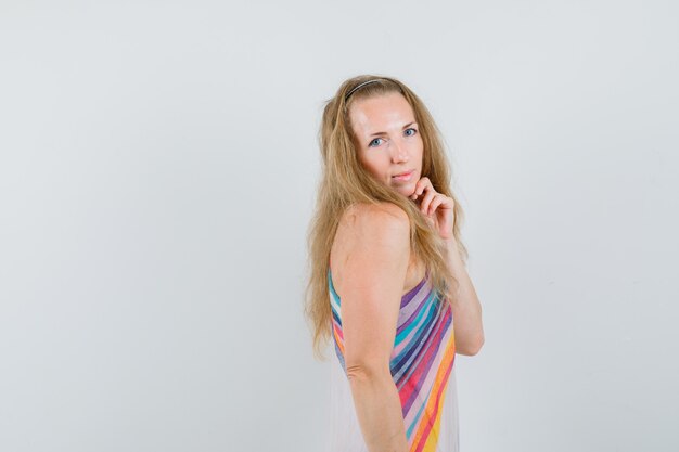 Young woman holding fingers on chin in summer dress and looking beautiful. .