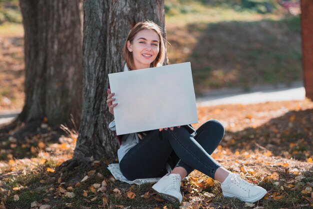 Молодая женщина держит рамку с copyspace