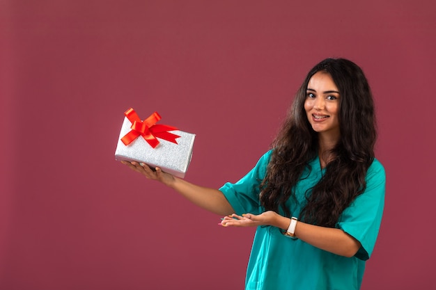 Free photo young woman holding gift box with red bow