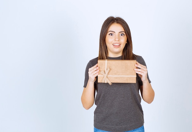 Free photo young woman holding a gift box .