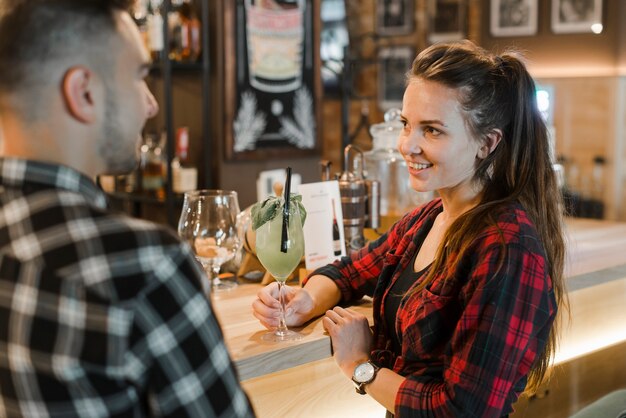 Young woman holding glass of drink dating her boyfriend